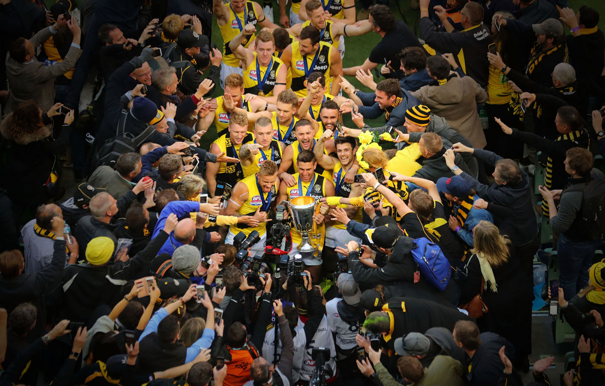 Richmond Tigers captain Trent Cotchin looks up as his team celebrates with the the 2017 AFL Premiership Cup, after beating the Adelaide in the Grand Final at the MCG.