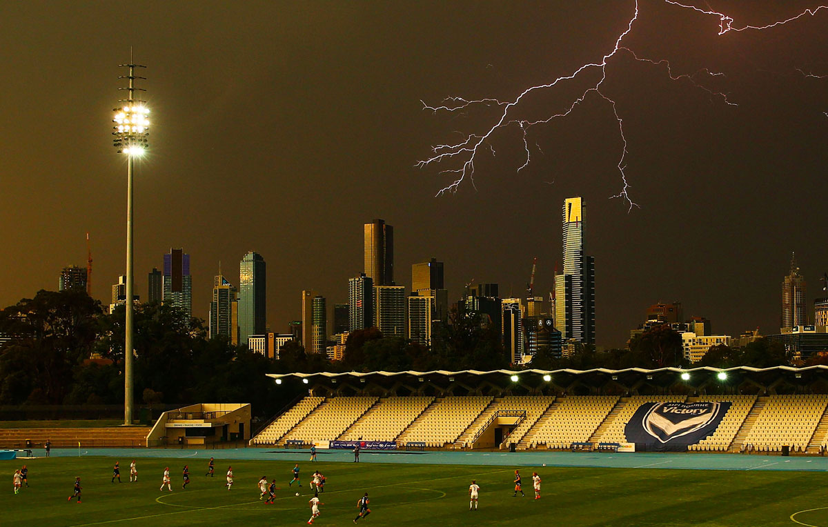 Players compete for the ball as lightning strikes in a W-League match between the Melbourne Victory and Western Sydney Wanderers in Melbourne. The match was suspended soon after.