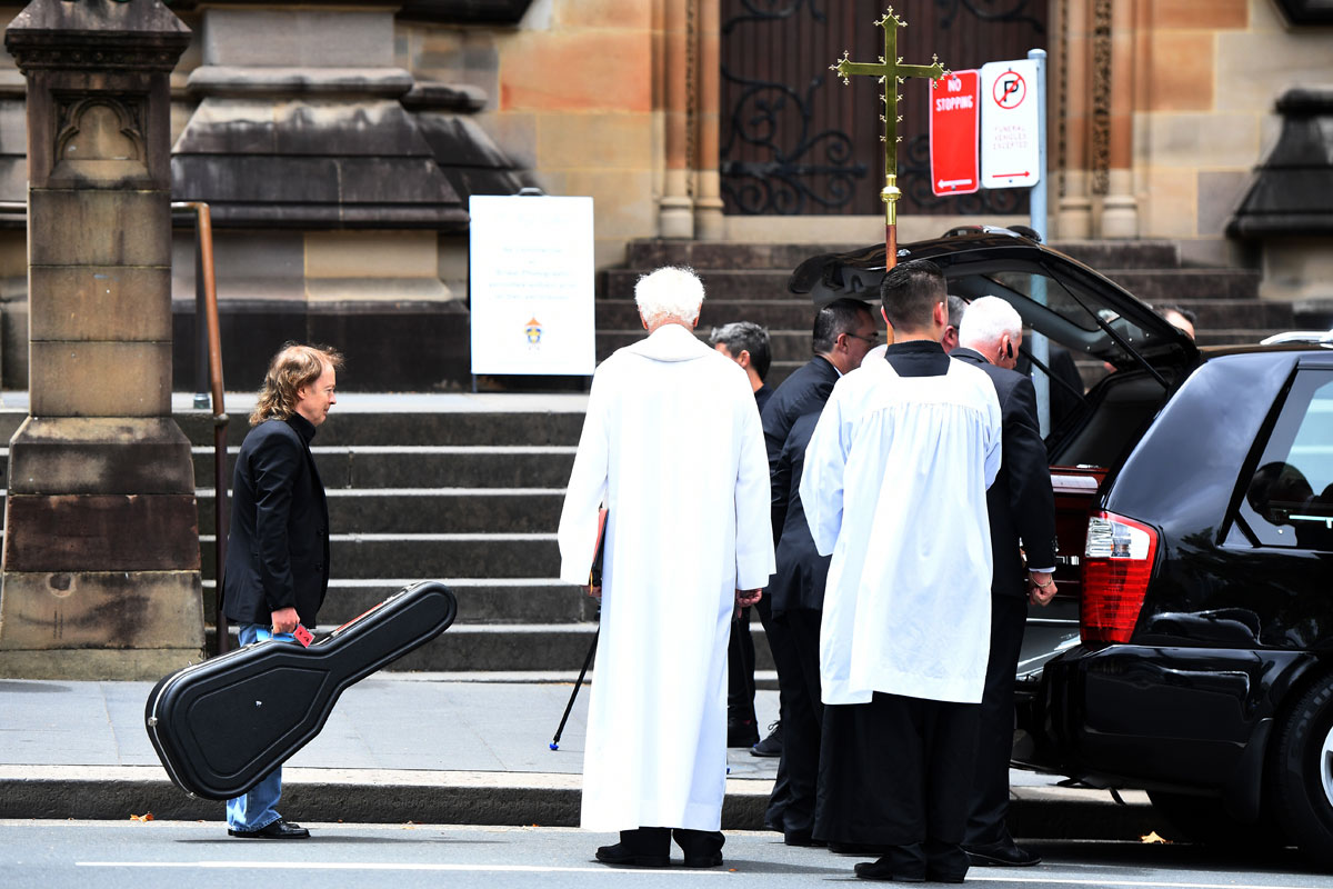 Angus Young waits to place a guitar in the hearse with the casket of his brother, AC/DC co-founder and guitarist Malcolm Young. The funeral was held at St. Mary's Cathedral in Sydney, in November 2017